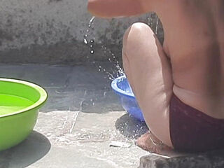 In the country's bathroom of the village, the elder sister-in-law's stepsister is soaking her saree in water and bathi