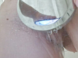 Teen shows close-up of her unshaven tight wet in the shower and caresses her with her fingers, dreaming of hot sex